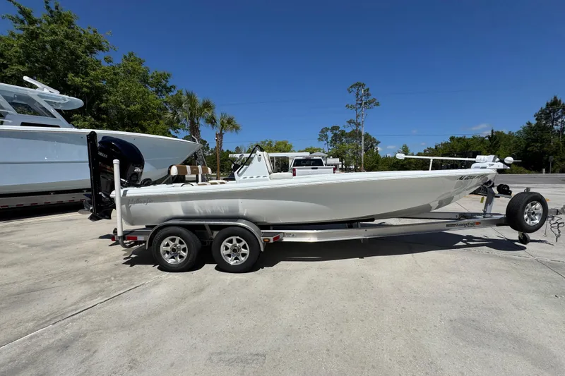 Slide: The Image of 2016 Yellowfin 21 Hybrid boat on trailer, parked outdoors under clear blue sky. - 10
