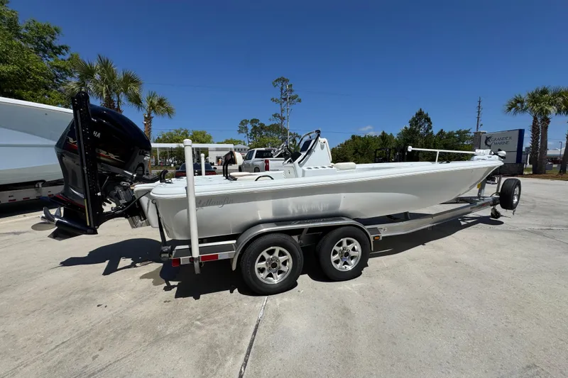 Slide: The Image of 2016 Yellowfin 21 Hybrid boat on trailer, parked outdoors under clear blue sky. - 11