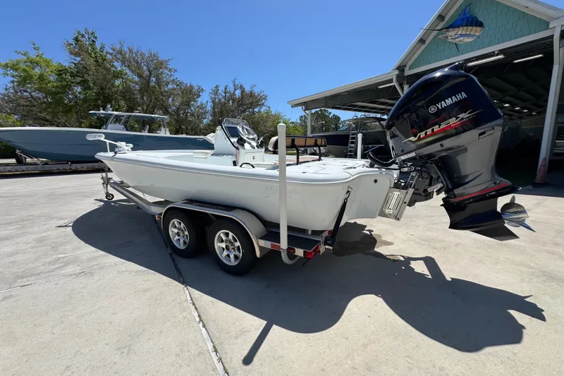 Slide: The Image of 2016 Yellowfin 21 Hybrid boat with Yamaha outboard motor on trailer, parked outdoors. - 17