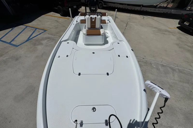 Slide: The Image of 2016 Yellowfin 21 Hybrid boat with spacious deck and seating, parked on concrete. - 22