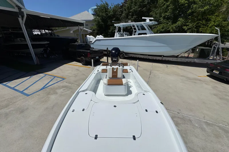 Slide: The Image of 2016 Yellowfin 21 Hybrid boat parked in a marina with other vessels nearby. - 23