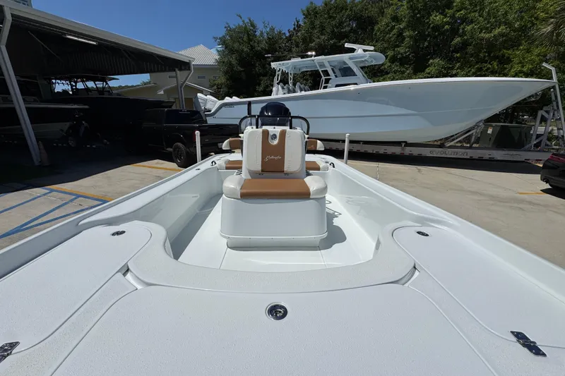 Slide: The Image of 2016 Yellowfin 21 Hybrid boat in a marina, showcasing sleek design and spacious deck. - 24