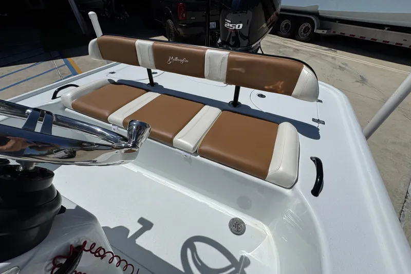 Slide: The Image of 2016 Yellowfin 21 Hybrid boat interior with tan and white seating, featuring a 250 horsepower engine. - 28