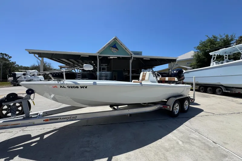 Slide: The Image of 2016 Yellowfin 21 Hybrid boat on trailer, parked outdoors under clear sky. - 3