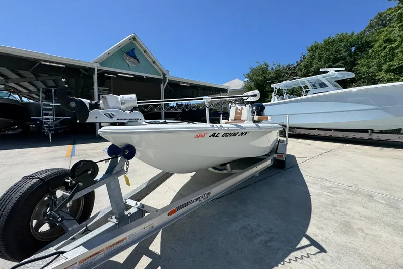 Slide: The Image of 2016 Yellowfin 21 Hybrid boat on trailer in marina under clear blue sky. - 5