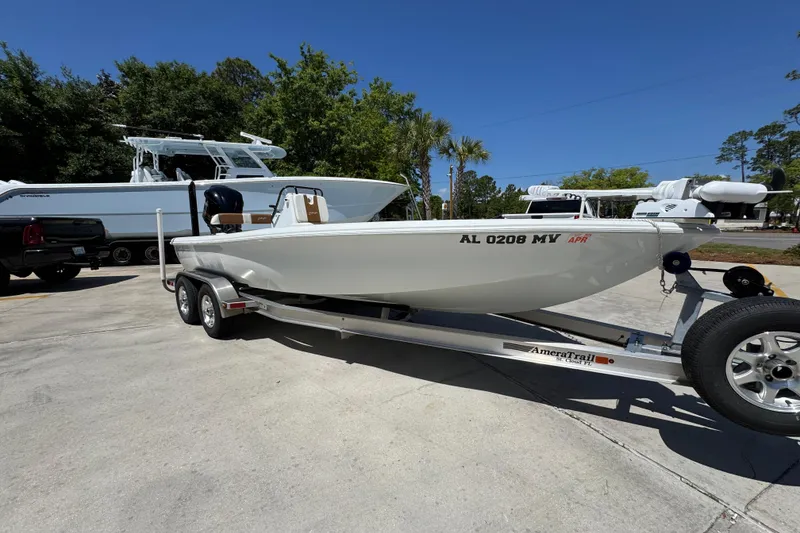 Slide: The Image of 2016 Yellowfin 21 Hybrid boat on trailer, parked outdoors under clear blue sky. - 8