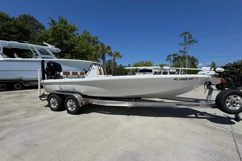 Slide: The Image of 2016 Yellowfin 21 Hybrid boat on trailer, parked outdoors under clear blue sky. - 9