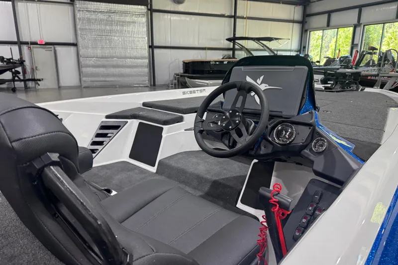 Slide: The Image of 2026 Skeeter ZXR21 SE boat interior with steering wheel and dashboard in a showroom. - 11
