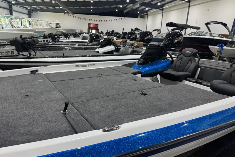 Slide: The Image of 2026 Skeeter ZXR21 SE boat displayed in a showroom with sleek design and seating. - 6