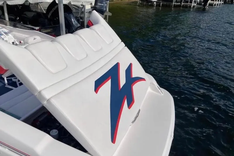 Slide: The Image of 2001 Donzi 28 ZX boat with distinctive logo, docked on a serene lake. - 5
