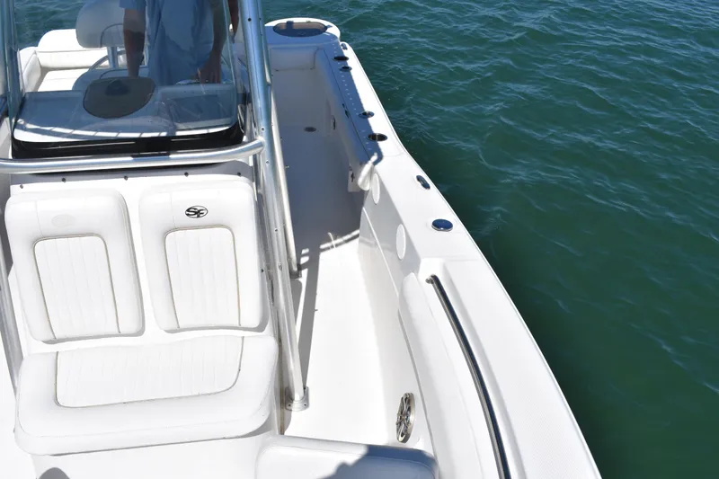 Slide: The Image of 2014 Sea Fox 226 Commander boat on water, featuring sleek white seating and console. - 16