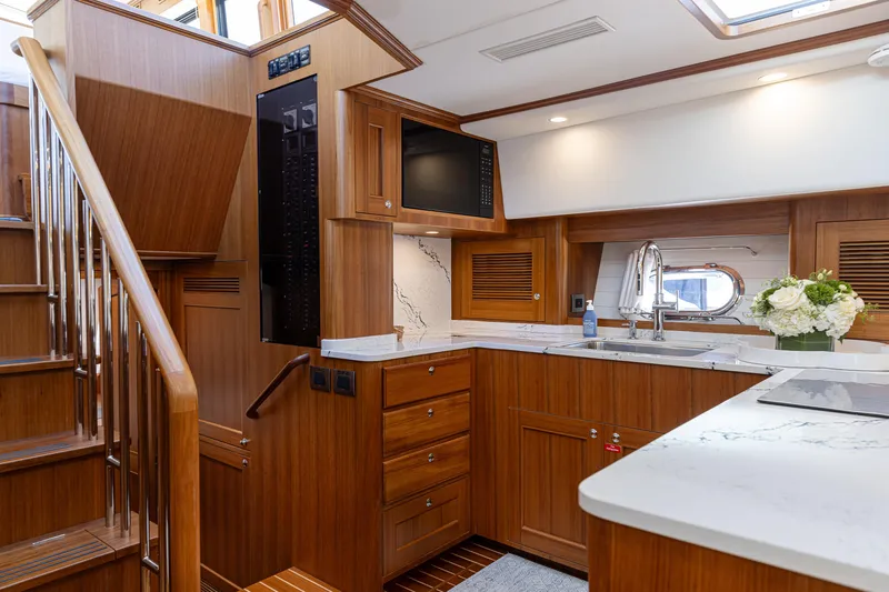 Slide: The Image of Luxurious kitchen interior of 2027 Hunt Yachts Ocean 63 Express with wood cabinetry and marble countertops. - 5
