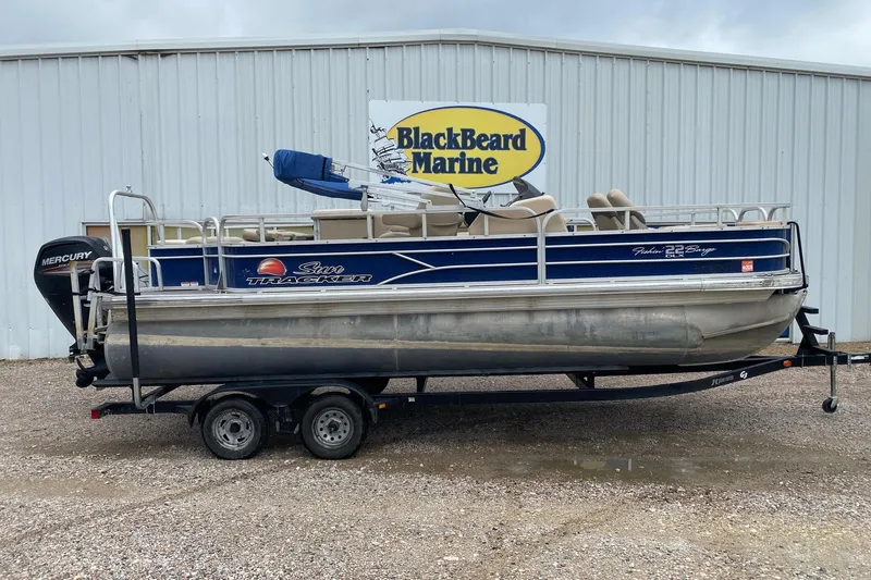 The Image of 2016 Sun Tracker Fishin' Barge 22 DLX pontoon boat on trailer at BlackBeard Marine. - 1