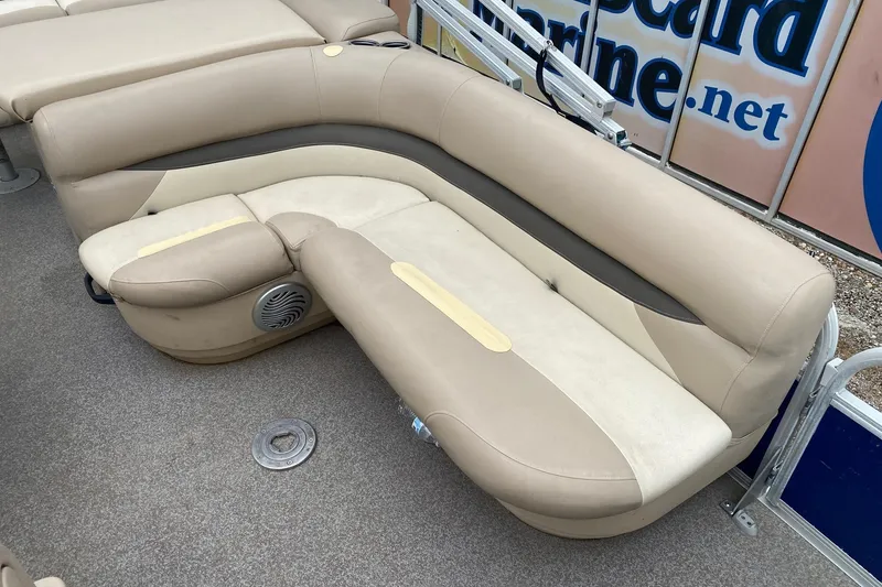 Slide: The Image of 2016 Sun Tracker Fishin' Barge 22 DLX beige seating with integrated speaker on boat deck. - 11