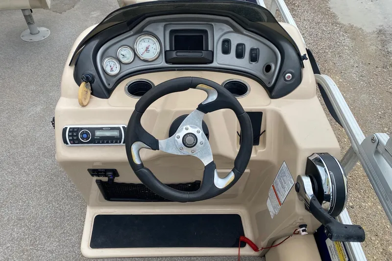 Slide: The Image of 2016 Sun Tracker Fishin' Barge 22 DLX dashboard with steering wheel and control panel. - 14