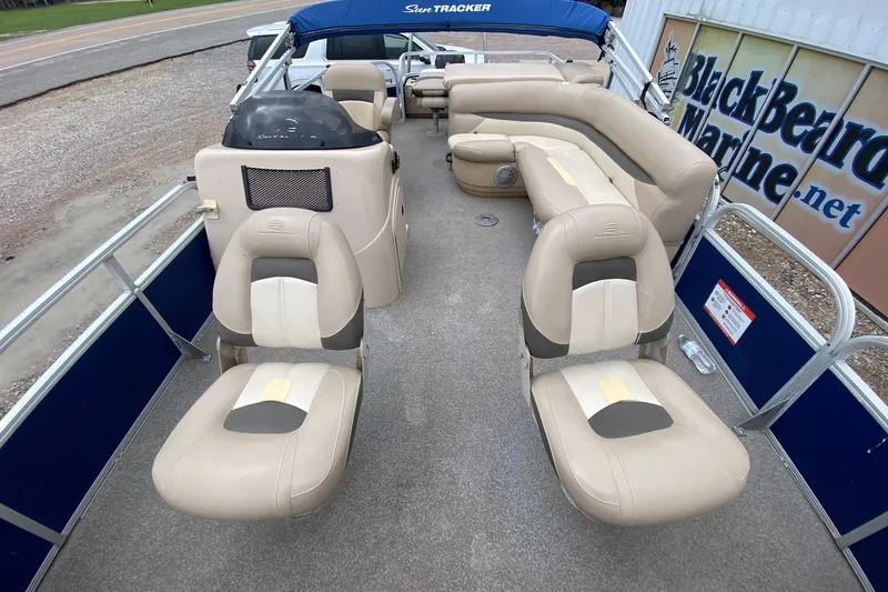 Slide: The Image of 2016 Sun Tracker Fishin' Barge 22 DLX interior with beige seating and helm. - 7
