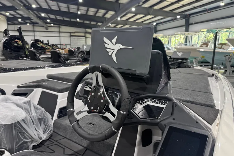 Slide: The Image of 2026 Skeeter FXR20 FLEX boat interior with steering wheel and dashboard in showroom. - 9