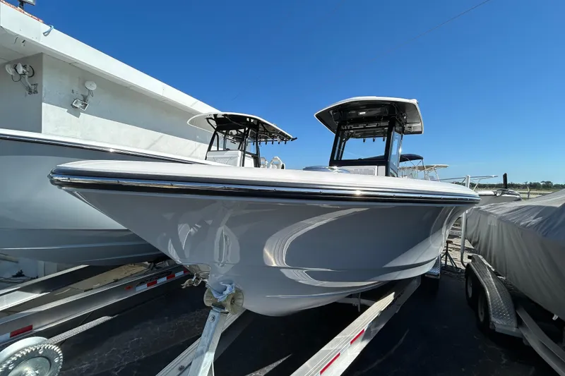 Slide: The Image of 2025 Robalo 266 Cayman boat on trailer, sleek design under clear blue sky. - 15