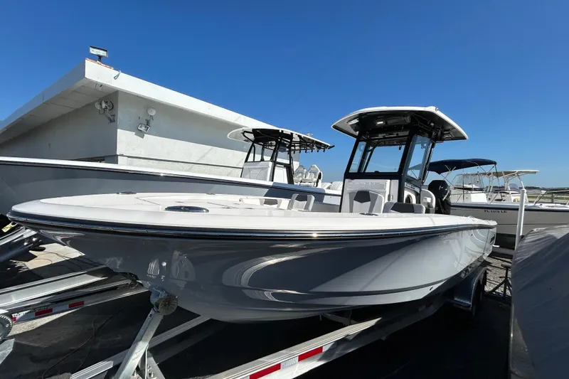 Slide: The Image of 2025 Robalo 266 Cayman boat displayed outdoors on a trailer under clear blue sky. - 17