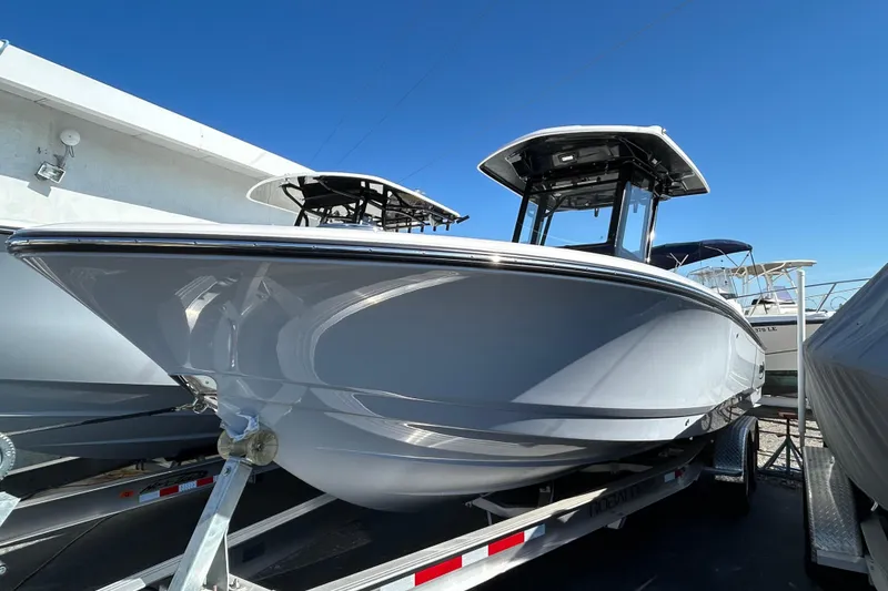 Slide: The Image of 2025 Robalo 266 Cayman boat on trailer under clear blue sky. - 4