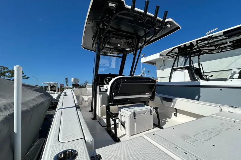 Slide: The Image of 2025 Robalo 266 Cayman boat interior with T-top and seating, under clear blue sky. - 6