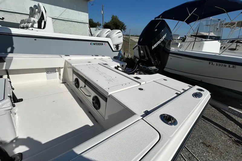 Slide: The Image of 2025 Robalo 266 Cayman boat with Mercury engine, docked beside other vessels. - 9