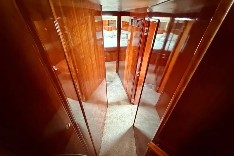 Slide: The Image of Hallway inside 2004 Riviera 51 Flybridge yacht with polished wood paneling and carpeted floor. - 21