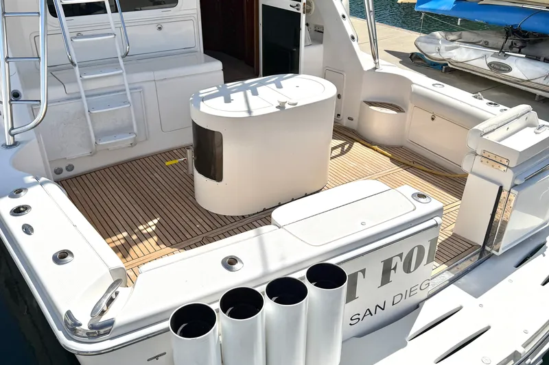 Slide: The Image of 2004 Riviera 51 Flybridge yacht deck with fishing rod holders, ladder, and seating area. - 4