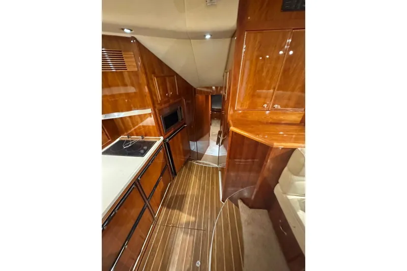 Slide: The Image of Luxurious 2004 Riviera 51 Flybridge yacht interior with polished wood finishes and modern amenities. - 10