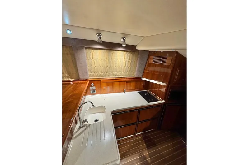 Slide: The Image of Luxurious 2004 Riviera 51 Flybridge yacht kitchen with wood cabinetry and modern appliances. - 11