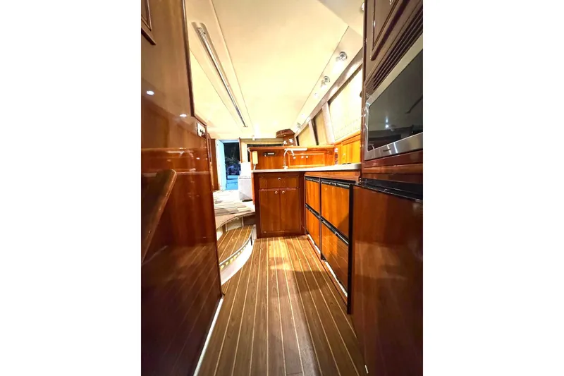 Slide: The Image of Luxurious interior of 2004 Riviera 51 Flybridge yacht with polished wood finishes. - 12