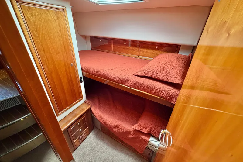 Slide: The Image of Interior of 2004 Riviera 51 Flybridge yacht with cozy bunk beds and wooden cabinetry. - 23