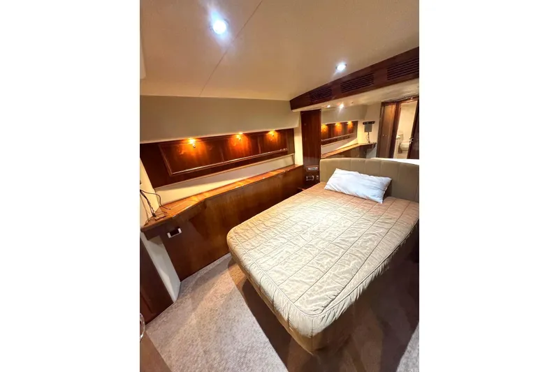 Slide: The Image of Luxurious bedroom interior of 2004 Riviera 51 Flybridge yacht with elegant wood finishes. - 14