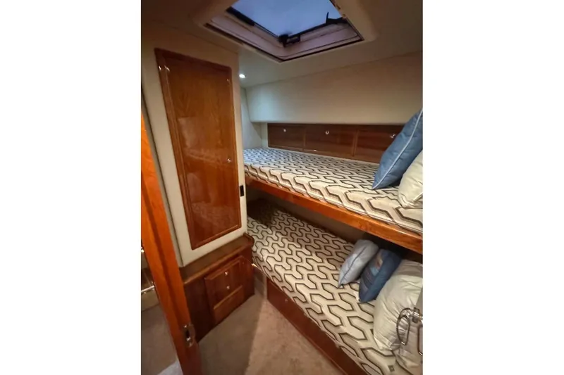 Slide: The Image of Interior of 2004 Riviera 51 Flybridge yacht with bunk beds and wooden cabinetry. - 15