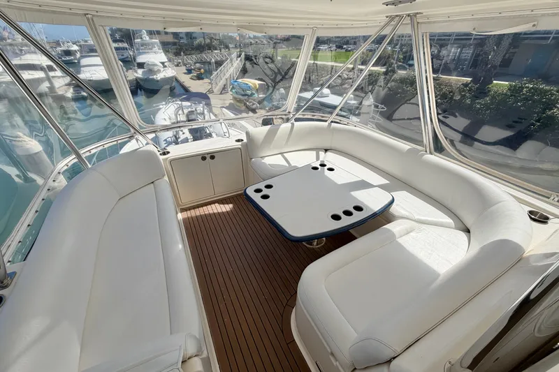 Slide: The Image of Luxurious 2004 Riviera 51 Flybridge interior with white seating and wooden flooring. - 26