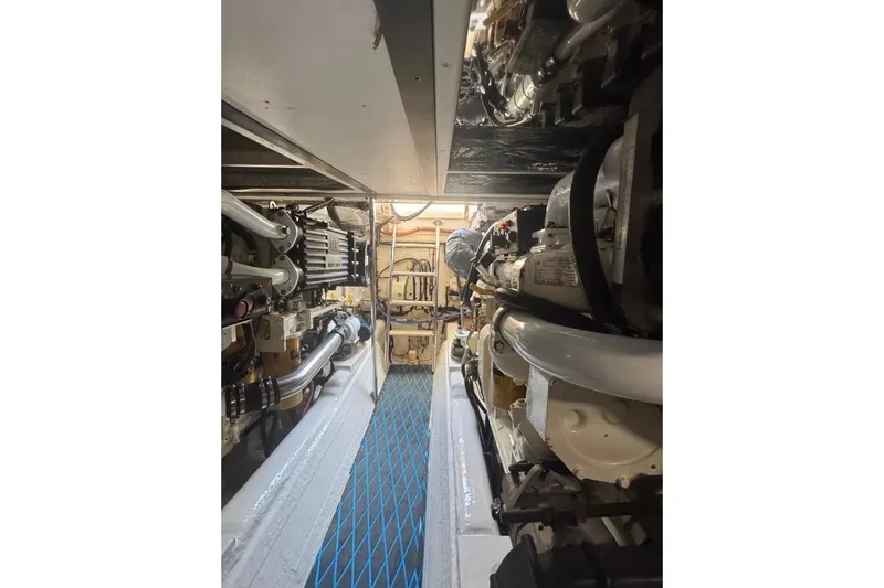 Slide: The Image of Engine room of 2004 Riviera 51 Flybridge yacht, showcasing mechanical components and piping. - 31