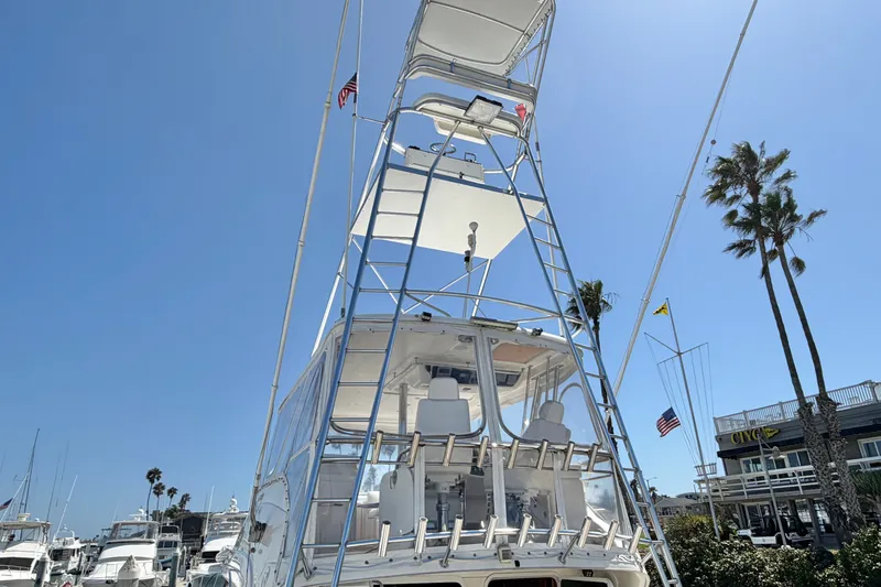 Slide: The Image of 2004 Riviera 51 Flybridge yacht with tower, docked under clear blue sky. - 5