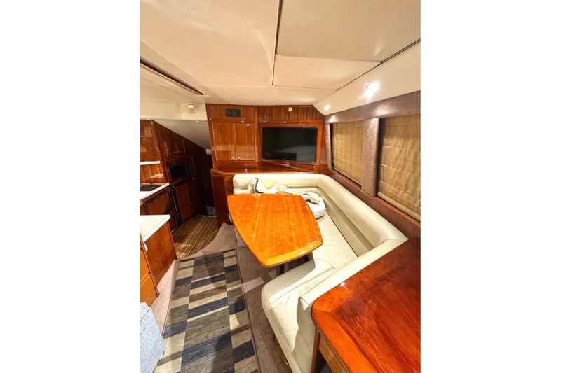 Slide: The Image of Luxurious interior of 2004 Riviera 51 Flybridge yacht with elegant wood finishes. - 6