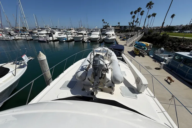 Slide: The Image of 2004 Riviera 51 Flybridge yacht docked at marina with boats and palm trees. - 33