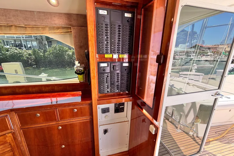 Slide: The Image of Interior view of 2004 Riviera 51 Flybridge showing control panel and wooden cabinetry. - 12