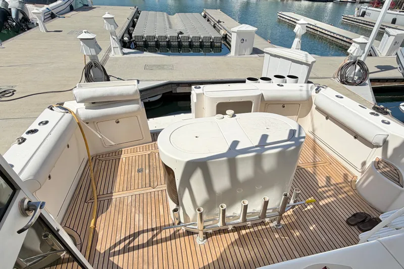 Slide: The Image of 2004 Riviera 51 Flybridge yacht deck with seating and fishing rod holders at marina. - 6