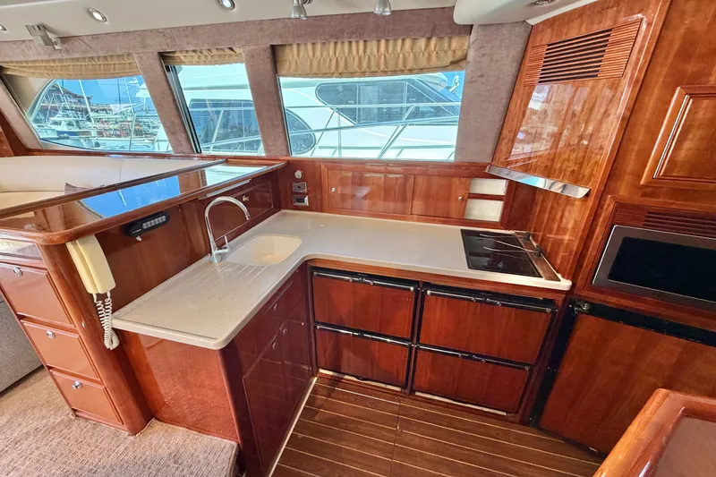 Slide: The Image of Luxurious 2004 Riviera 51 Flybridge yacht kitchen with wood cabinetry and modern appliances. - 16