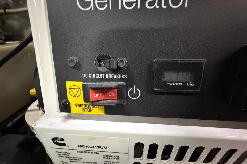 Slide: The Image of Control panel of a generator with emergency stop and circuit breakers on a 2004 Riviera 51 Flybridge. - 47