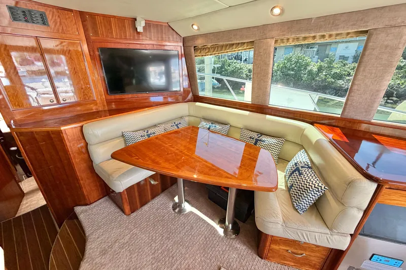 Slide: The Image of Luxurious interior of 2004 Riviera 51 Flybridge yacht with plush seating and wooden finishes. - 8