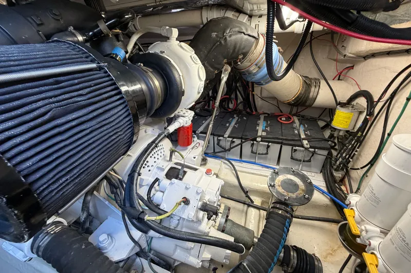 Slide: The Image of Engine room of a 2004 Riviera 51 Flybridge yacht, showcasing mechanical components and wiring. - 37