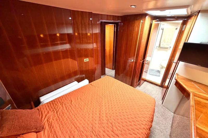 Slide: The Image of Luxurious cabin interior of 2004 Riviera 51 Flybridge yacht with wood paneling and cozy bedding. - 22