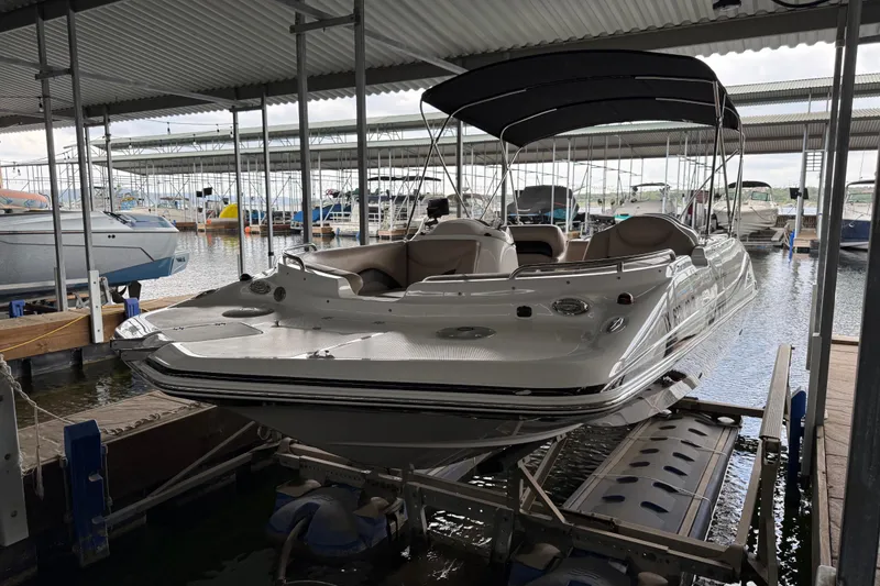Slide: The Image of 2014 Hurricane SunDeck Sport 202 IO boat docked in a marina under a covered shelter. - 16