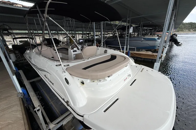 Slide: The Image of 2014 Hurricane SunDeck Sport 202 IO boat docked under a covered marina. - 18