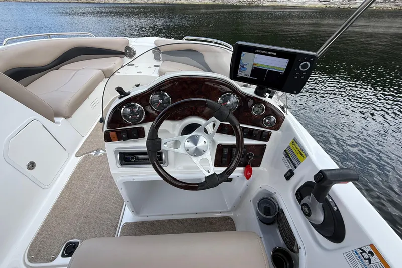 Slide: The Image of 2014 Hurricane SunDeck Sport 202 IO boat dashboard with steering wheel and navigation system. - 25