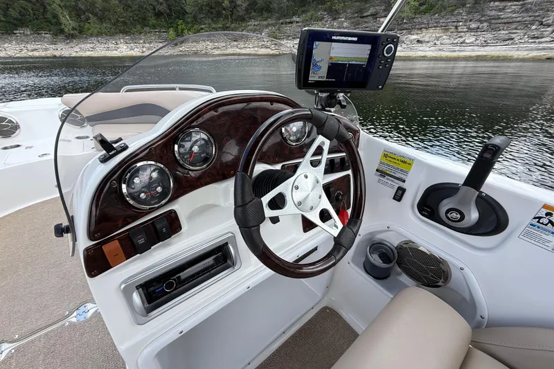 Slide: The Image of 2014 Hurricane SunDeck Sport 202 IO boat dashboard with steering wheel and navigation system. - 26